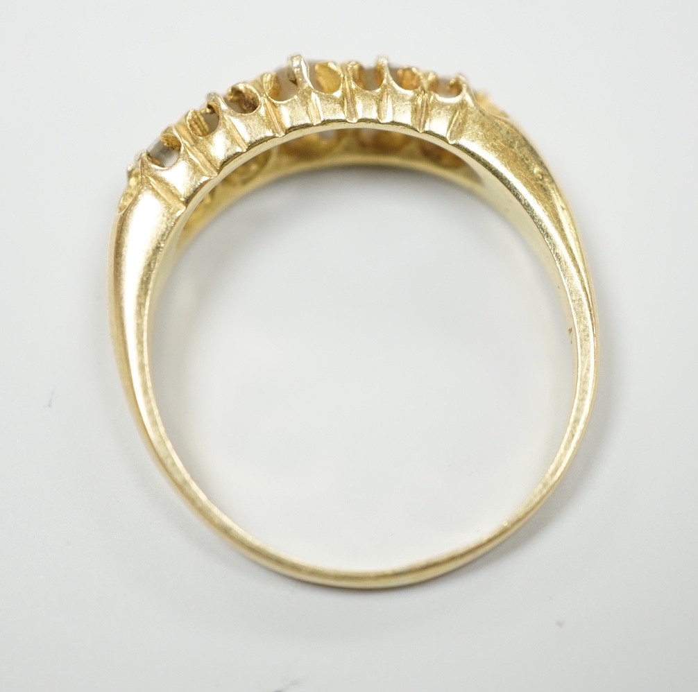 An early 20th century gold and graduated five stone diamond set half hoop ring, size O/P, gross weight 4.3 grams.